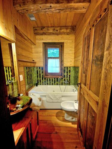 a bathroom with a tub and a toilet and a sink at Chalet Euthalia Restaurant & Suites in San Giacomo