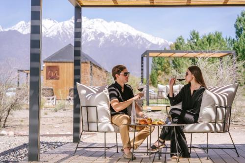 a man and woman sitting at a table drinking wine at La Morada Lodge - Valle de Uco in Vista Flores