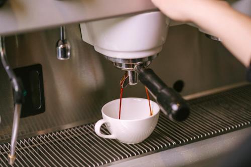 a person is making a cup of coffee at La Morada Lodge - Valle de Uco in Vista Flores