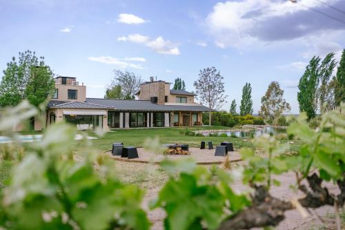 a house with a fire pit in the yard at La Morada Lodge - Valle de Uco in Vista Flores