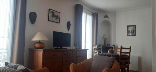 - un salon avec une télévision sur une commode en bois dans l'établissement Charmant studio à Montmartre, à Paris