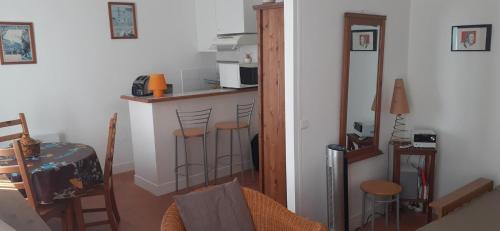 une cuisine avec un comptoir et un bar avec tabourets dans l'établissement Charmant studio à Montmartre, à Paris