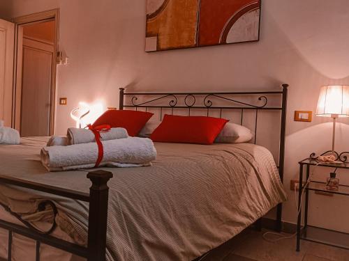 ein Schlafzimmer mit einem Bett mit zwei roten Kissen in der Unterkunft Il Casale di David in Pontedera