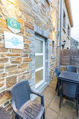 a patio with chairs and a table and a building at Nouvel appartement très confortable avec cuisine et frigo in Anhée