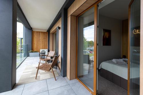 a room with a balcony with a bed and a window at Laguna Beskidów Resort, Jezioro Żywieckie in Bierna