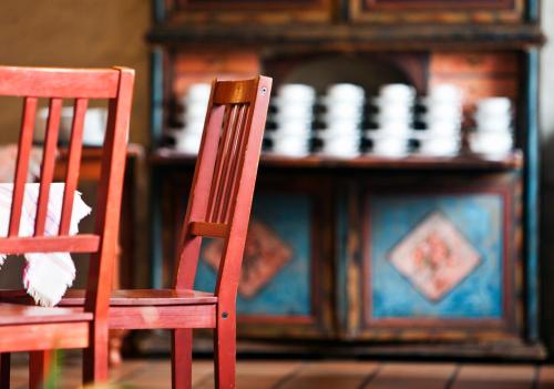 two red chairs sitting in front of a wooden cabinet at Sahlströmsgården in Torsby