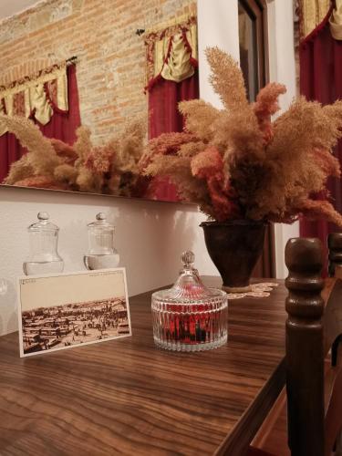 a table with a picture and a vase on it at Domus Hotel in Korçë