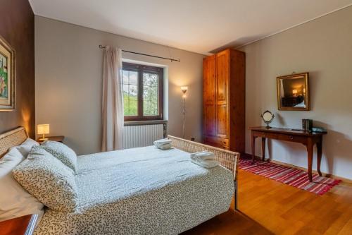 a bedroom with a bed and a table and a window at Villa Tra Vigne e Stelle in Neive