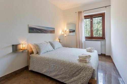 a white bedroom with a bed and a window at Villa Tra Vigne e Stelle in Neive
