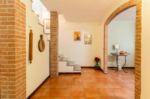 a hallway with a brick wall and a staircase at Villa Tra Vigne e Stelle in Neive