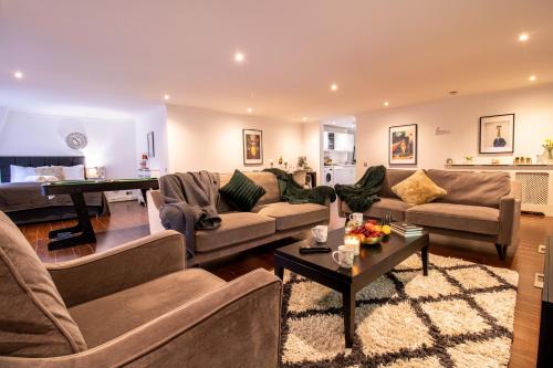 ein Wohnzimmer mit Sofas und einem Klavier in der Unterkunft Luxurious Apartments in Mayfair in London