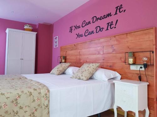 a bedroom with a bed with a sign on the wall at CasaMarichelvas in San Asensio