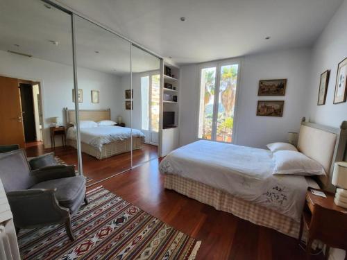 a bedroom with two beds and a glass wall at Villa Bethanie in Villefranche-sur-Mer