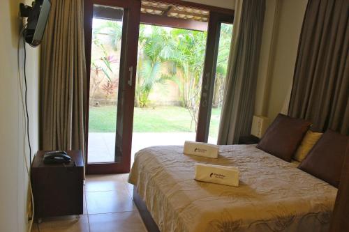 um quarto com uma cama com duas caixas em Qavi - Pipa Beleza Resort em Pipa