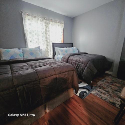 a bedroom with two beds and a window at Divine Villa Guest House Harper Ave EWR AIRPORT PENN STATION NY NJ in Irvington