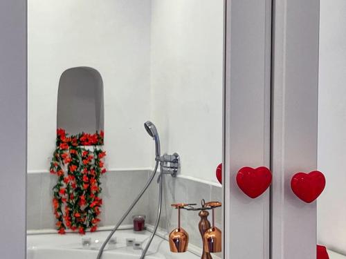 a bathroom with a sink with a mirror and red roses at Amalfi Rooms Duoglio Beach -amazing seaview in Amalfi