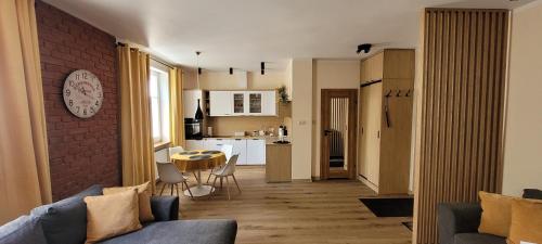 ein Wohnzimmer und eine Küche mit einer Couch und einem Tisch in der Unterkunft Gold Apartament in Olsztyn