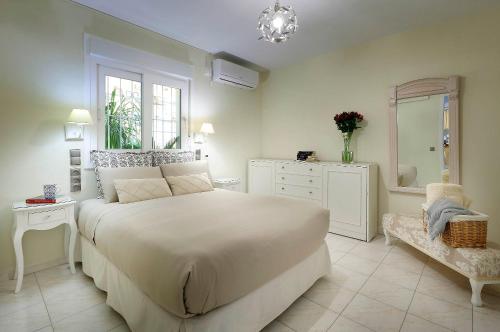 um quarto com uma grande cama branca e uma janela em Apartamento Jardín Cerca del Centro em Sevilha