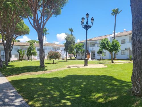 a park with palm trees and a building at Apartamento Pinar del Atlántico La Barrosa in Chiclana de la Frontera