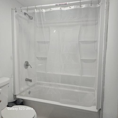 a white shower with empty shelves in a bathroom at Divine Villa Guest House Harper Ave EWR AIRPORT PENN STATION NY NJ in Irvington
