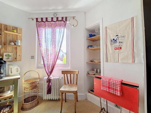 une cuisine avec une chaise rouge et une fenêtre dans l'établissement Mi Casita Azul, à Caen