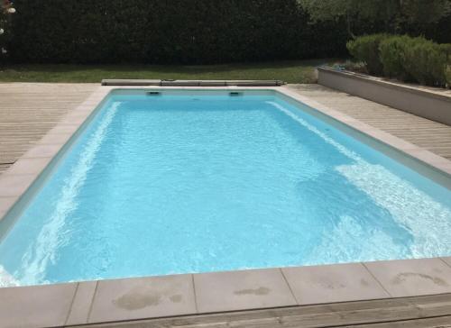 une piscine avec de l'eau bleue dans une cour dans l'établissement Bungalow, à Sorède