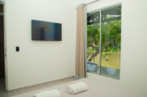 Habitación blanca con ventana grande y toalla en Casa del Lago en Copacabana