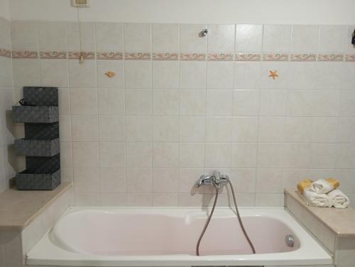 Una bañera blanca con grifo en un baño. en Casa vacanze da viola, en Ugento