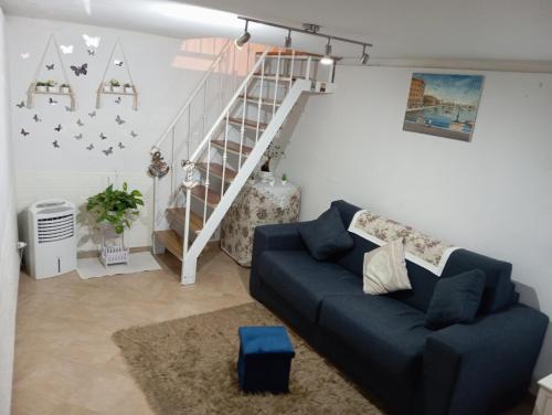 ein Wohnzimmer mit einem blauen Sofa und einer Treppe in der Unterkunft Amalia B&b San francesco in Bari