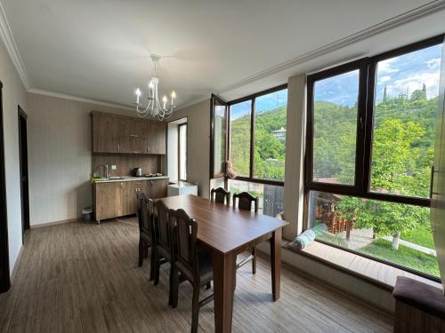 a dining room with a table and chairs and windows at Spitak tun in Ijevan