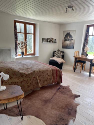 sypialnia z łóżkiem, stołem i pianinem w obiekcie Maison Bardoz w mieście Le Clerjus