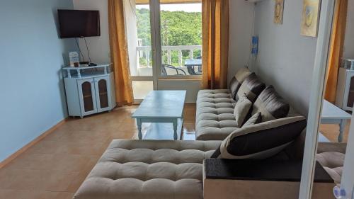 uma sala de estar com um sofá e uma mesa em Guest House Chalakov em Sinemorets