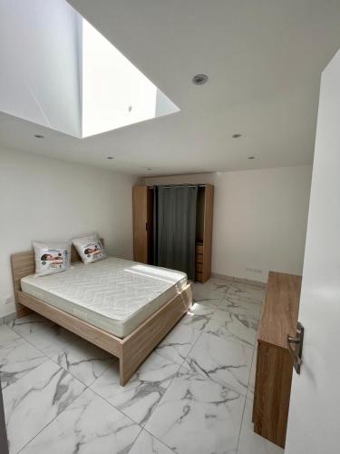 - une chambre avec un lit dans une pièce dotée d'un sol en marbre dans l'établissement Maison 5 couchages bien située, à Marseille