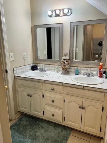 a bathroom with two sinks and two mirrors at Quite and Beautiful Stay in Montgomery