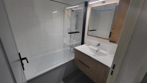 une salle de bain avec une douche, un lavabo et un miroir dans l'établissement Appartement 4 à 6 personnes - Chalets d'Aurouze - La Joue du Loup, à Saint-Étienne-en-Dévoluy
