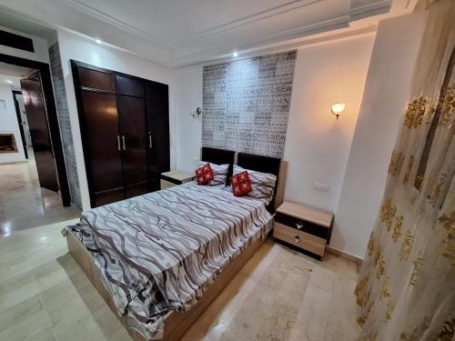 卡薩布蘭卡的住宿－Reservyou，一间卧室配有一张带红色枕头的床