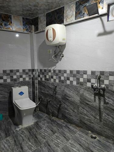 a bathroom with a toilet and a phone on the wall at Hotel Fateh Heights in Pāndukeshwar