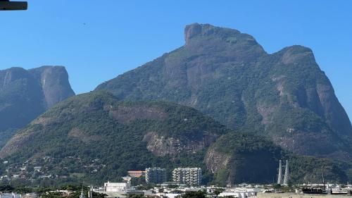 Una montaña con una ciudad delante de ella en Vista para o mar Barra da tijuca, en Río de Janeiro