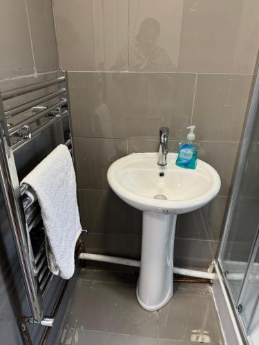 baño con lavabo blanco y toalla en High street home en Eastleigh