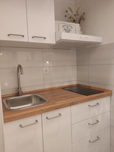 een keuken met witte kasten en een spoelbak bij Apartments Mimi Omis in Omiš