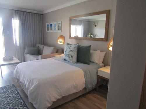 1 dormitorio con 1 cama grande y sala de estar en ShipsBell 5B, en St Francis Bay