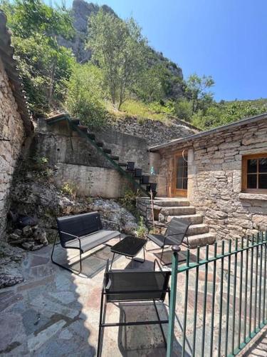 a patio with chairs and a staircase and a building at Gîte de la Bergère in La Malène