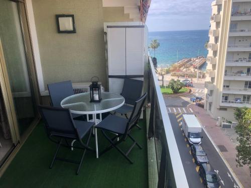 balcón con mesa, sillas y vistas al océano en Studio Juan les Pins, en Juan-les-Pins