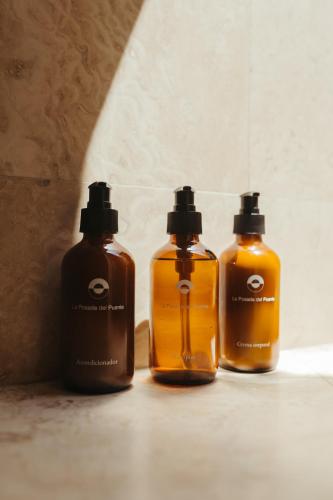 three bottles of soap sitting on the floor at La Posada del Puente in Arequipa