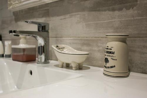 a bathroom counter with a sink and a bottle of soap at Studios Liotrivi Ouranoupolis in Ouranoupoli