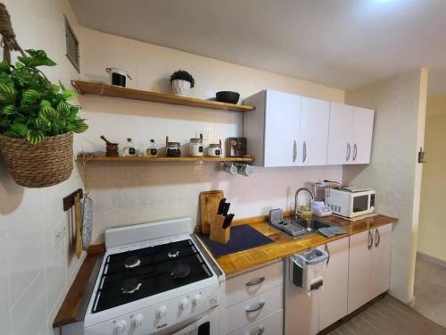 a kitchen with white cabinets and a stove top oven at Ritasol Palace apartamento de relax frente al mar in Caraballeda