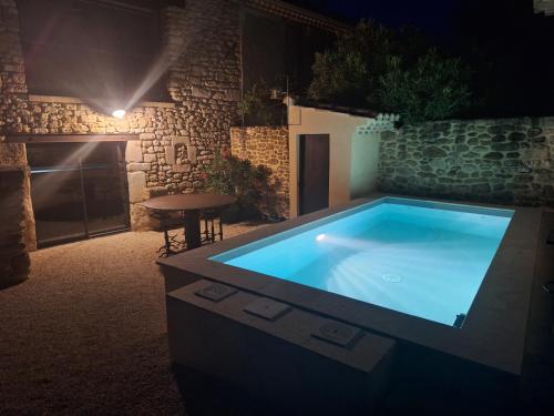 a large swimming pool in a yard at night at Chez Véro chambres d'hôtes & Maison en pierre contemporaine in Suze-la-Rousse