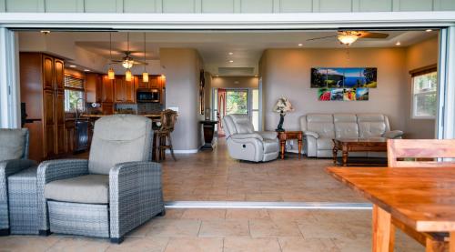 a living room with chairs and a table at Kailua-Kona Exceptional Oceanview Home - Heated Oasis Pool & Stunning Ocean View in Kailua-Kona