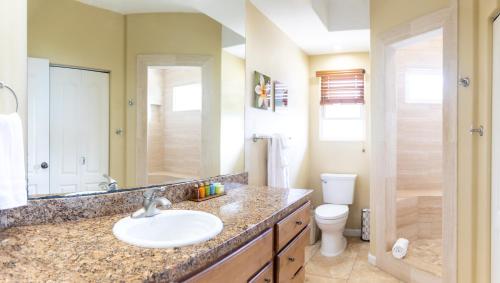a bathroom with a sink and a toilet at Kailua-Kona Exceptional Oceanview Home - Heated Oasis Pool & Stunning Ocean View in Kailua-Kona