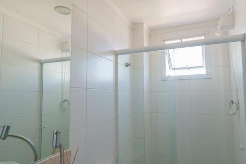 uma casa de banho com um chuveiro e uma porta de vidro em VISTA PRAIA MAR - AVIAÇÃO - 300 metros da praia - WI FI - VARANDA GOURMET com CHURRASQUEIRA - ESTACIONAMENTO gratuito na Praia Grande